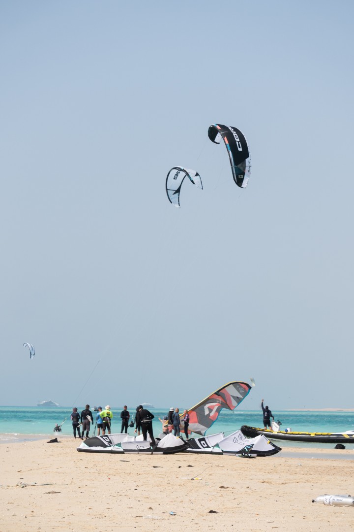 Group setting up kites on the beach